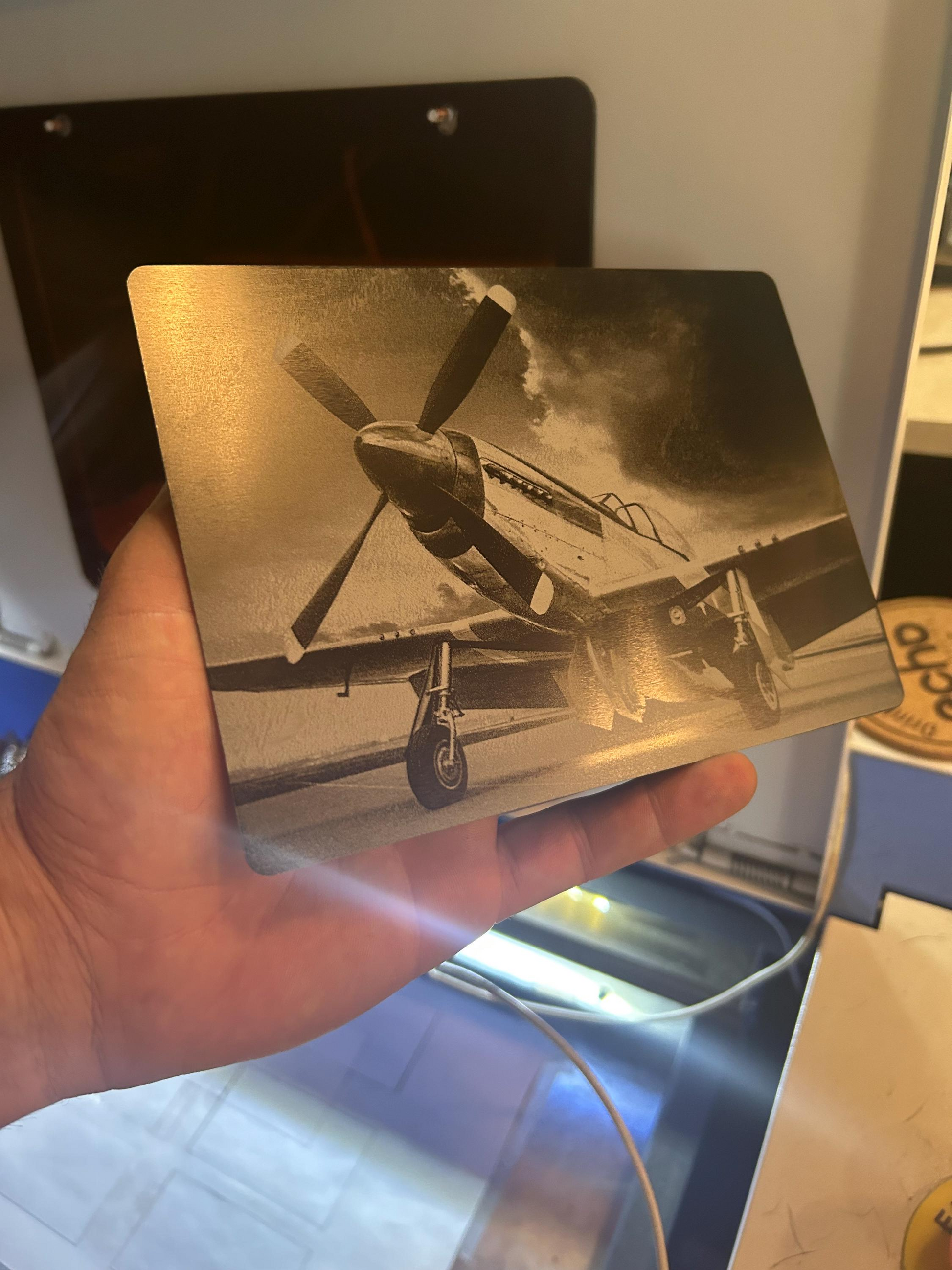 Hand holding laser engraved aviation plaque gift with P-51 on runway artwork