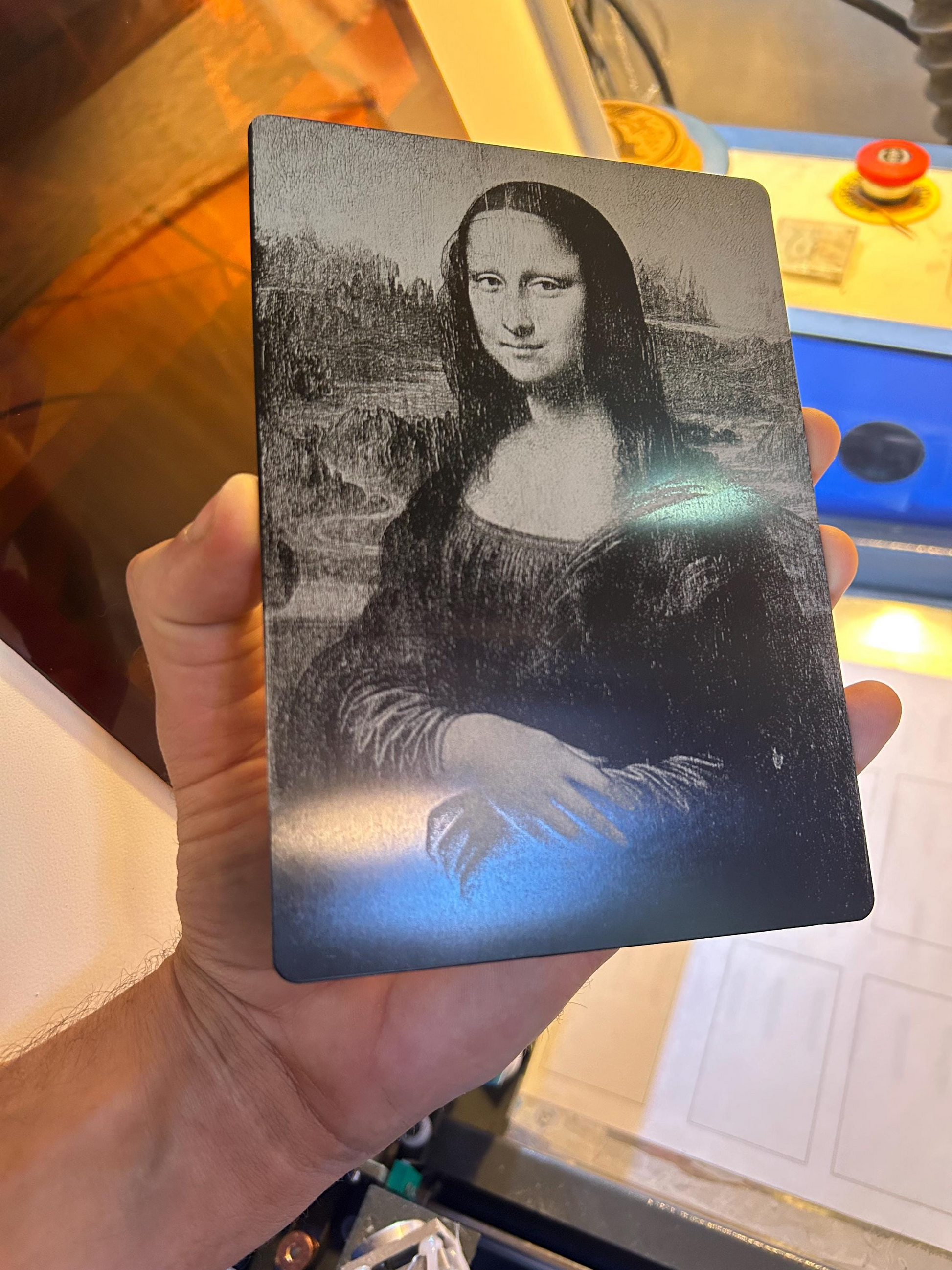 Hand holding a metal 5x7 plaque with a laser engraved image of Mona Lisa