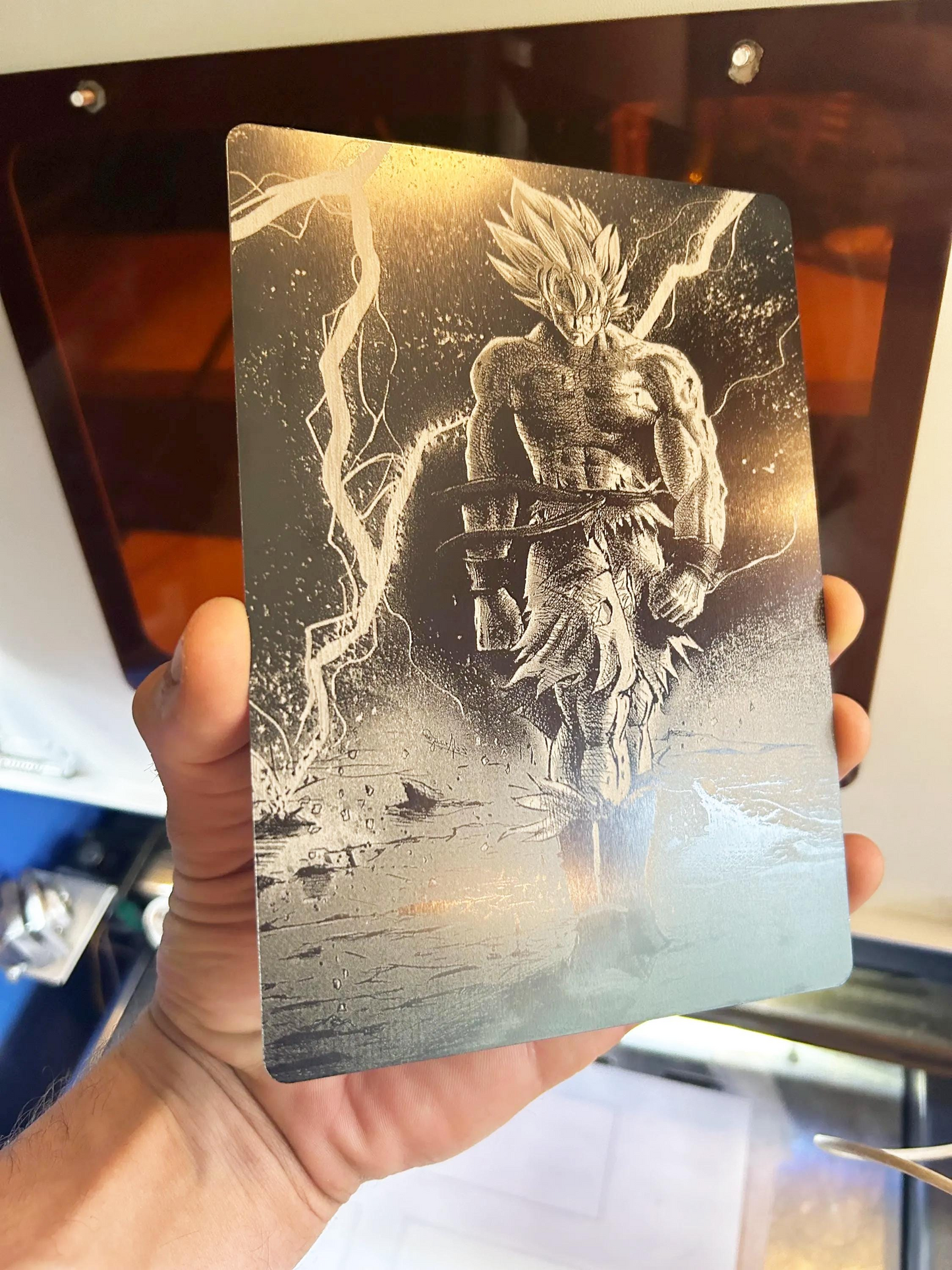 Metallic card with a manga fan art illustration design laser engraved in anodized aluminum held by a person