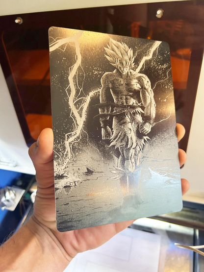 Metallic card with a manga fan art illustration design laser engraved in anodized aluminum held by a person