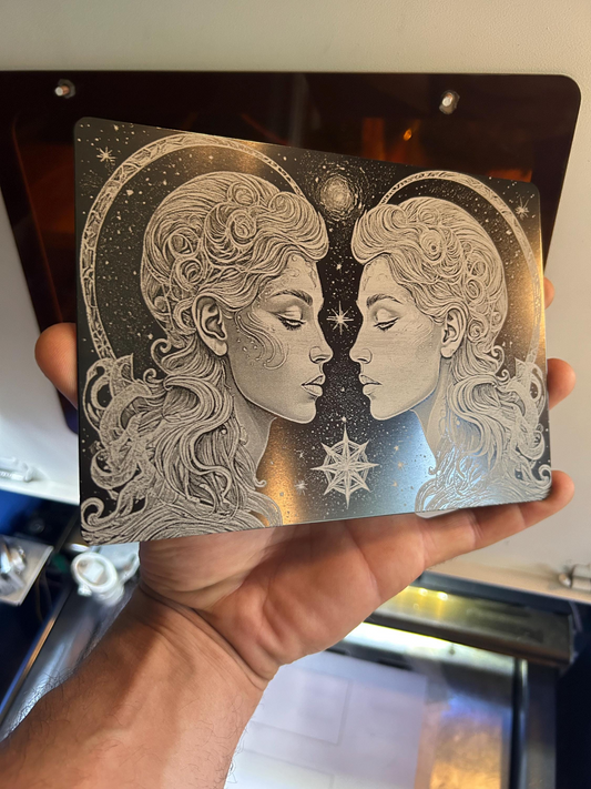 Hand holding a laser engraved decorative plaque with intricate gemini twin artwork