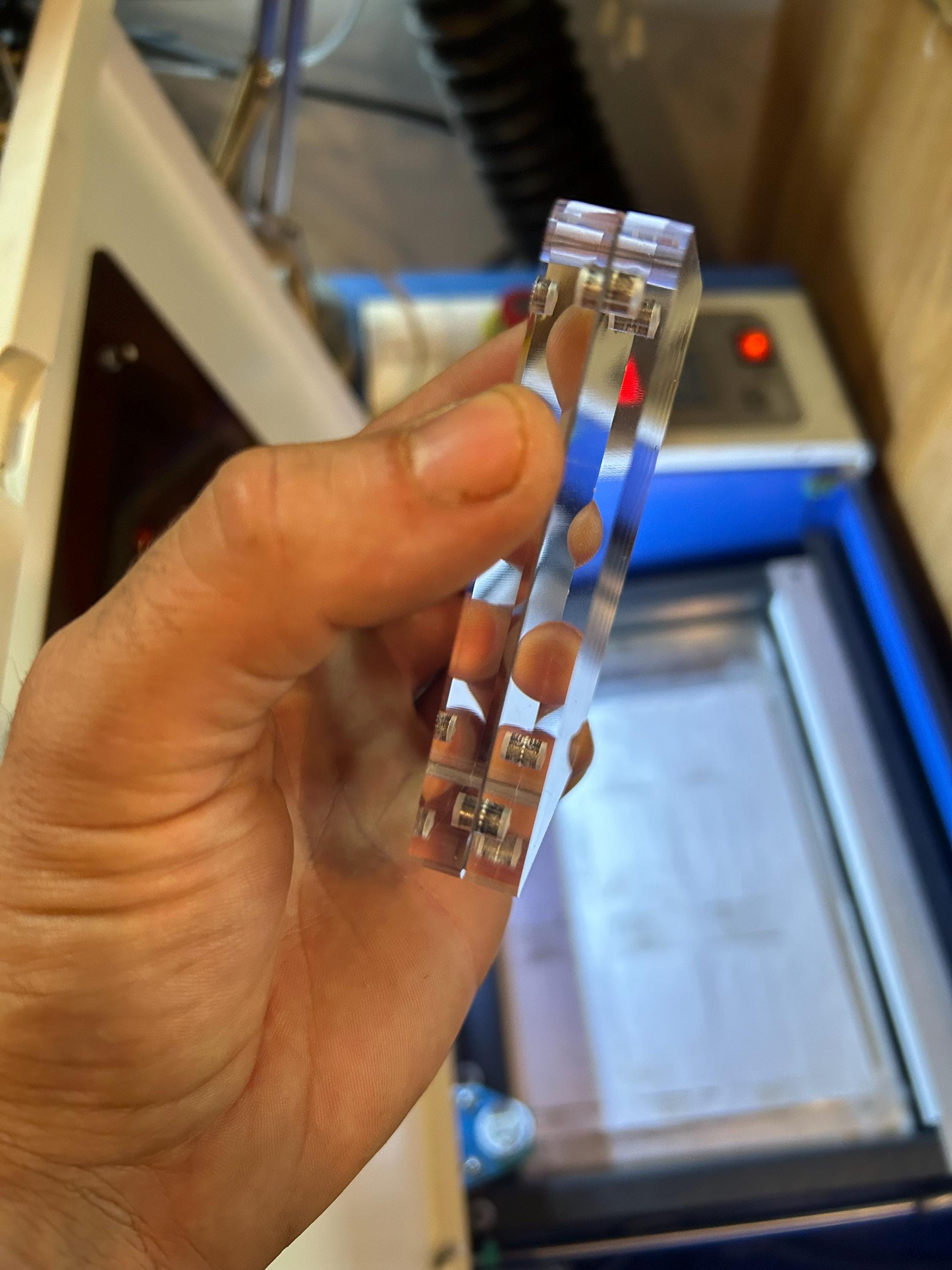 Hand holding an acrylic display case with a blurred background