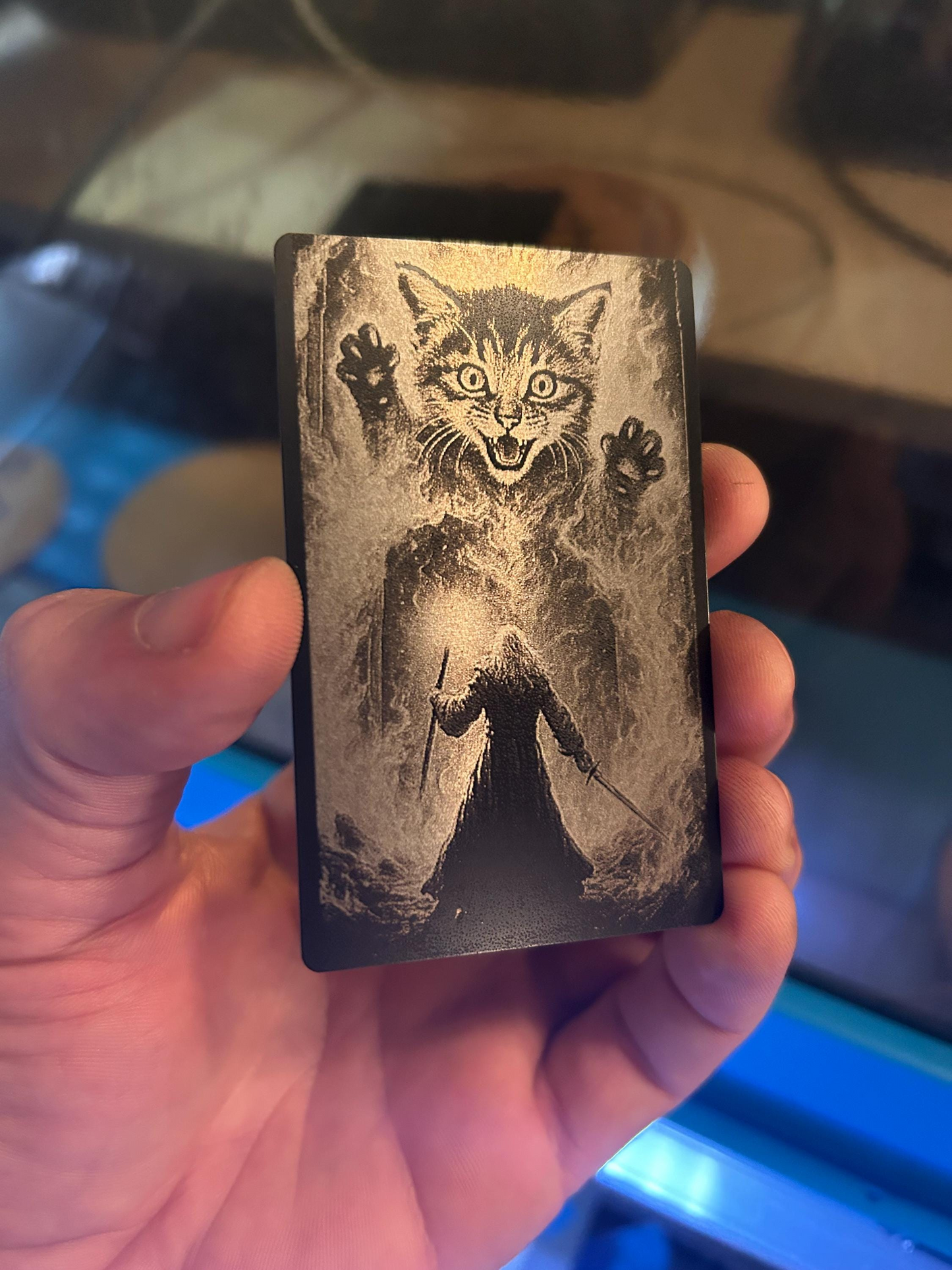 hand holding laser engraved metal crazy cat play time keepsake card in black/silver anodized aluminum