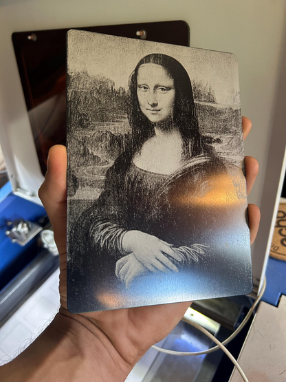 Hand holding a laser engraved metal decorative plaque size 5x7" of the Mona Lisa