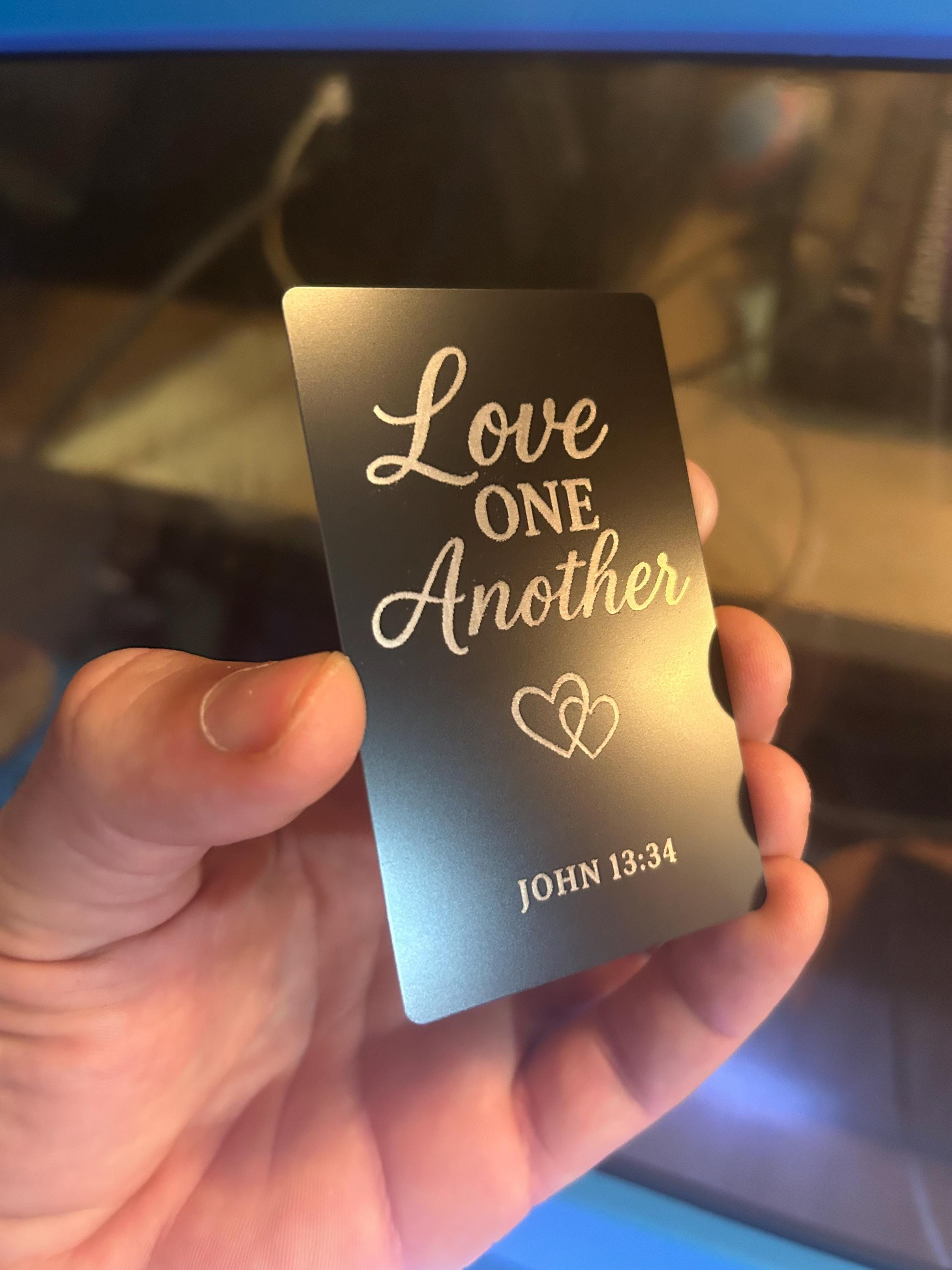 Detailed view of custom black metal Christian gift plaque engraved with “Love One Another” and John 13:34 scripture