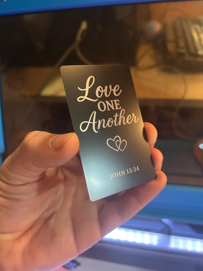Angled shot of engraved anodized aluminum Bible verse plaque – “Love One Another” scripture gift