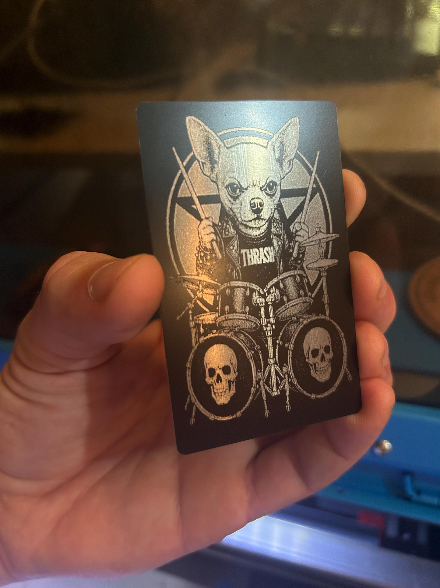 Hand holding an anodized aluminum novelty musician gift card with heavy metal chihuahua percussionist graphic
