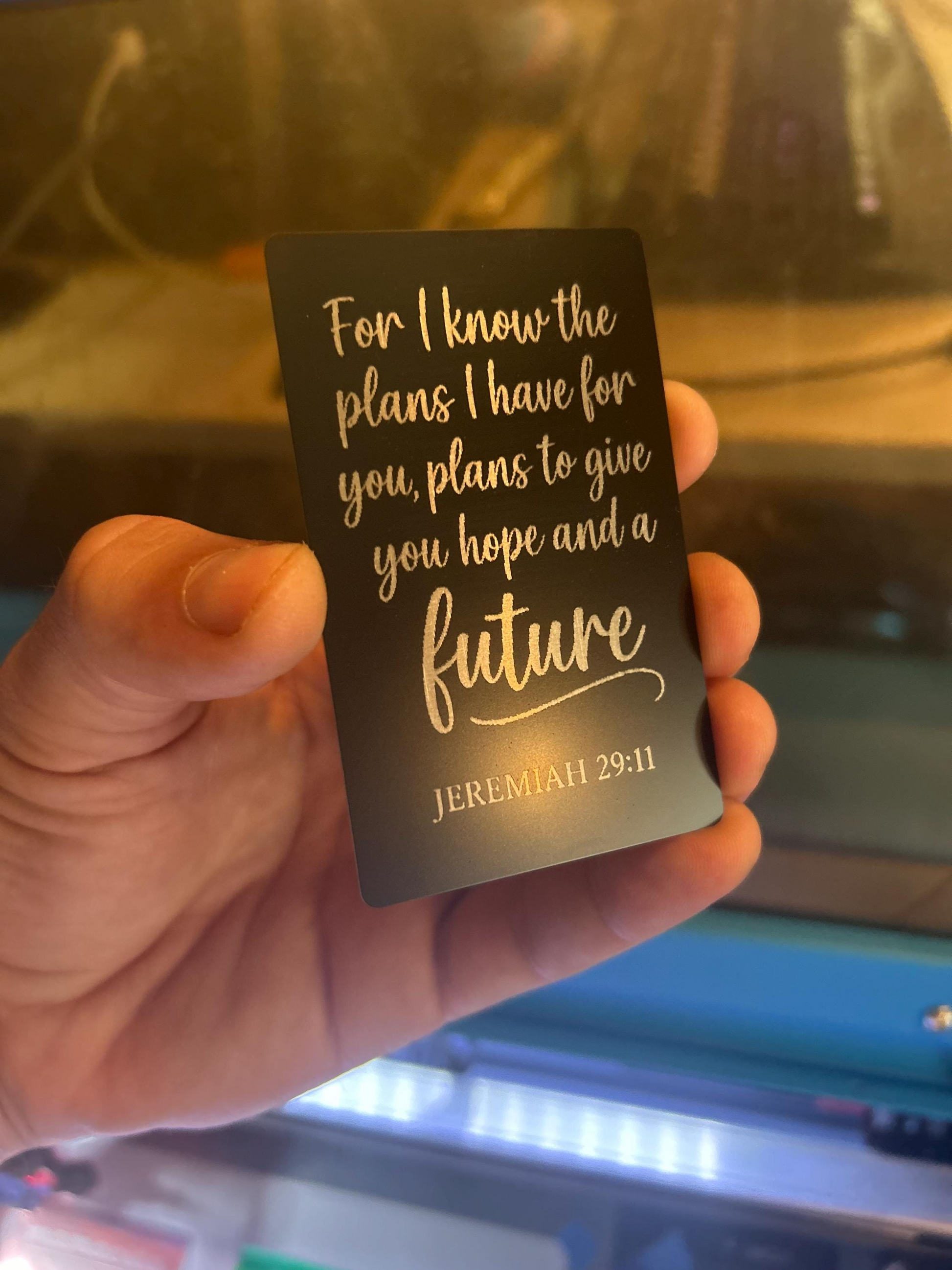 Detailed view of engraved anodized aluminum inspirational card with Jeremiah 29:11 verse in silver on black finish