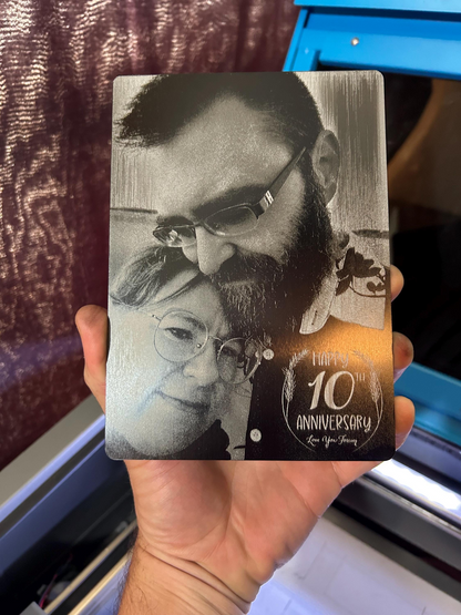 5x7 metal decorative plaque with black and white photo laser engraved of a couple and '10th Anniversary' text held by a person.
