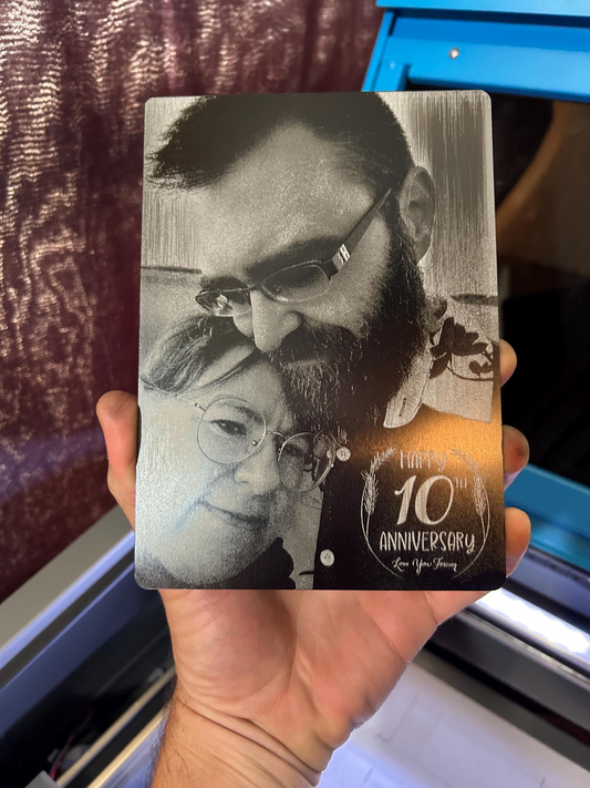 5x7 metal decorative plaque with black and white photo laser engraved of a couple and '10th Anniversary' text held by a person.
