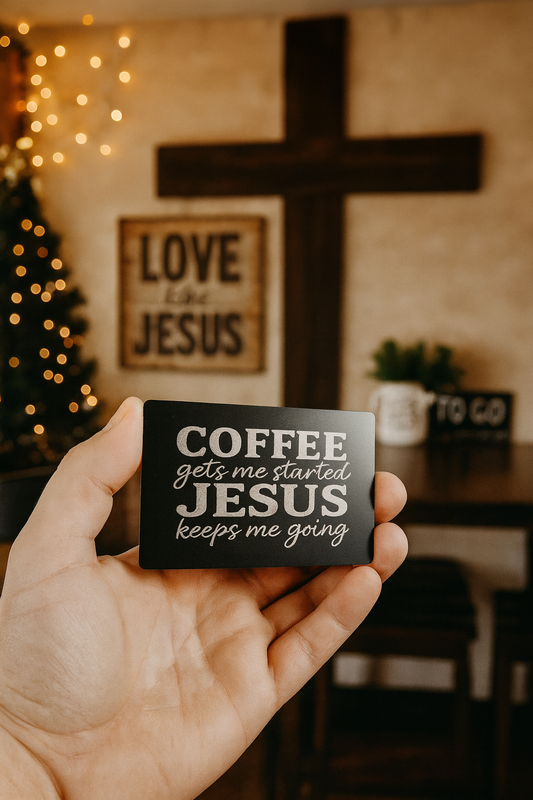 Hand holding a small metal sign with 'Coffee gets me started, Jesus keeps me going' text in a Christian coffee shop setting.