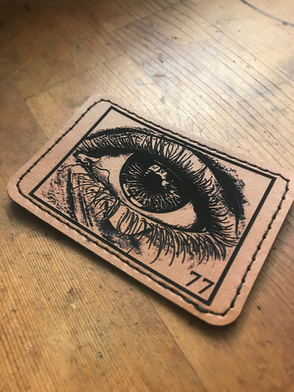 Leather eye ball patch with laser engraved highly detailed surreal illustration and angel 77 numbers
