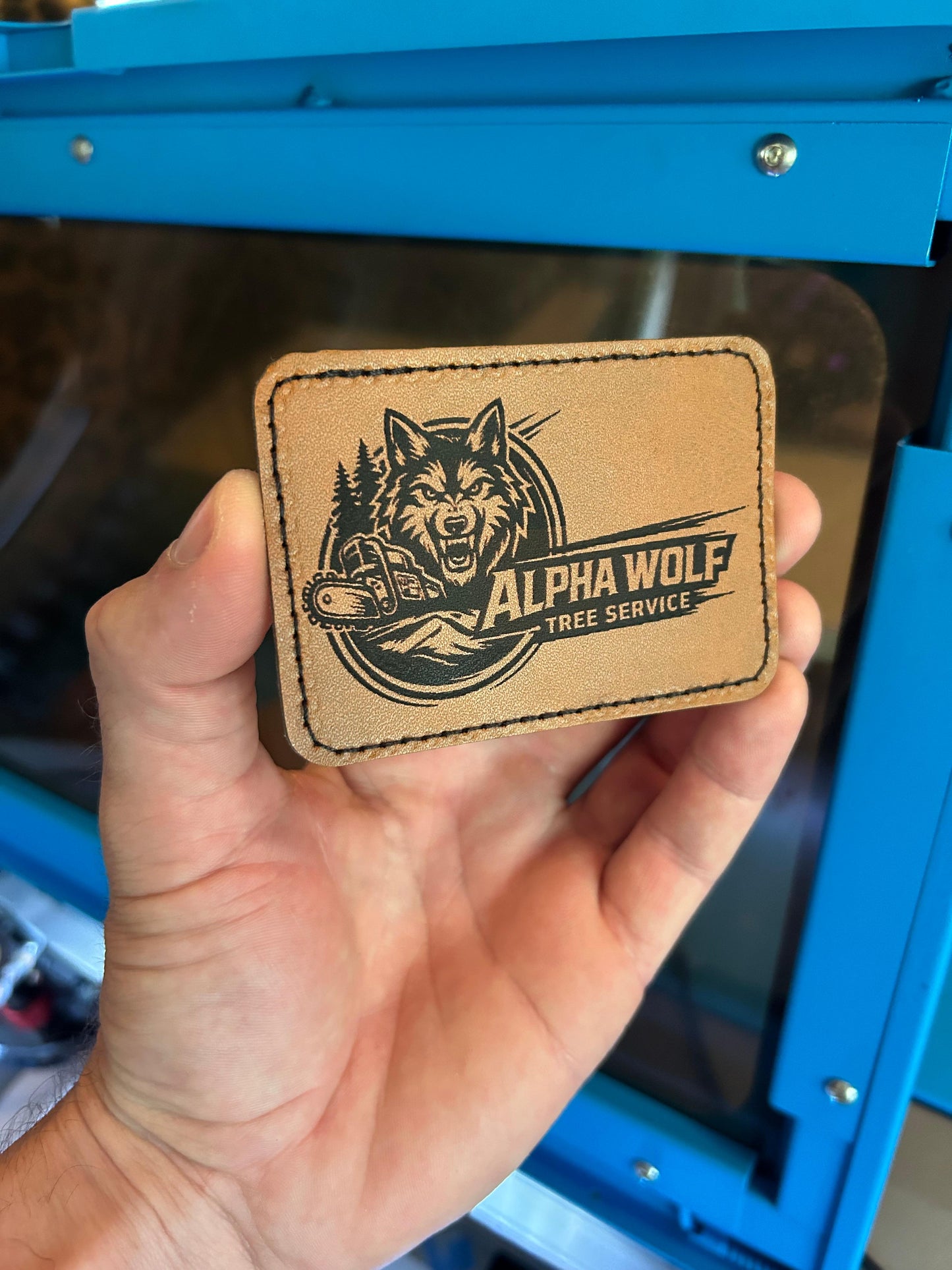 Laser engraved leather patch with Tree Service branding engraved in brown 