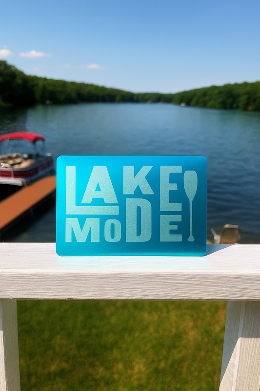 Lake Mode placard on a dock with a lake and boat in the background