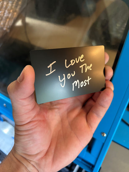 Laser engraved metal keepsake that reads I Love You The Most in black/silver
