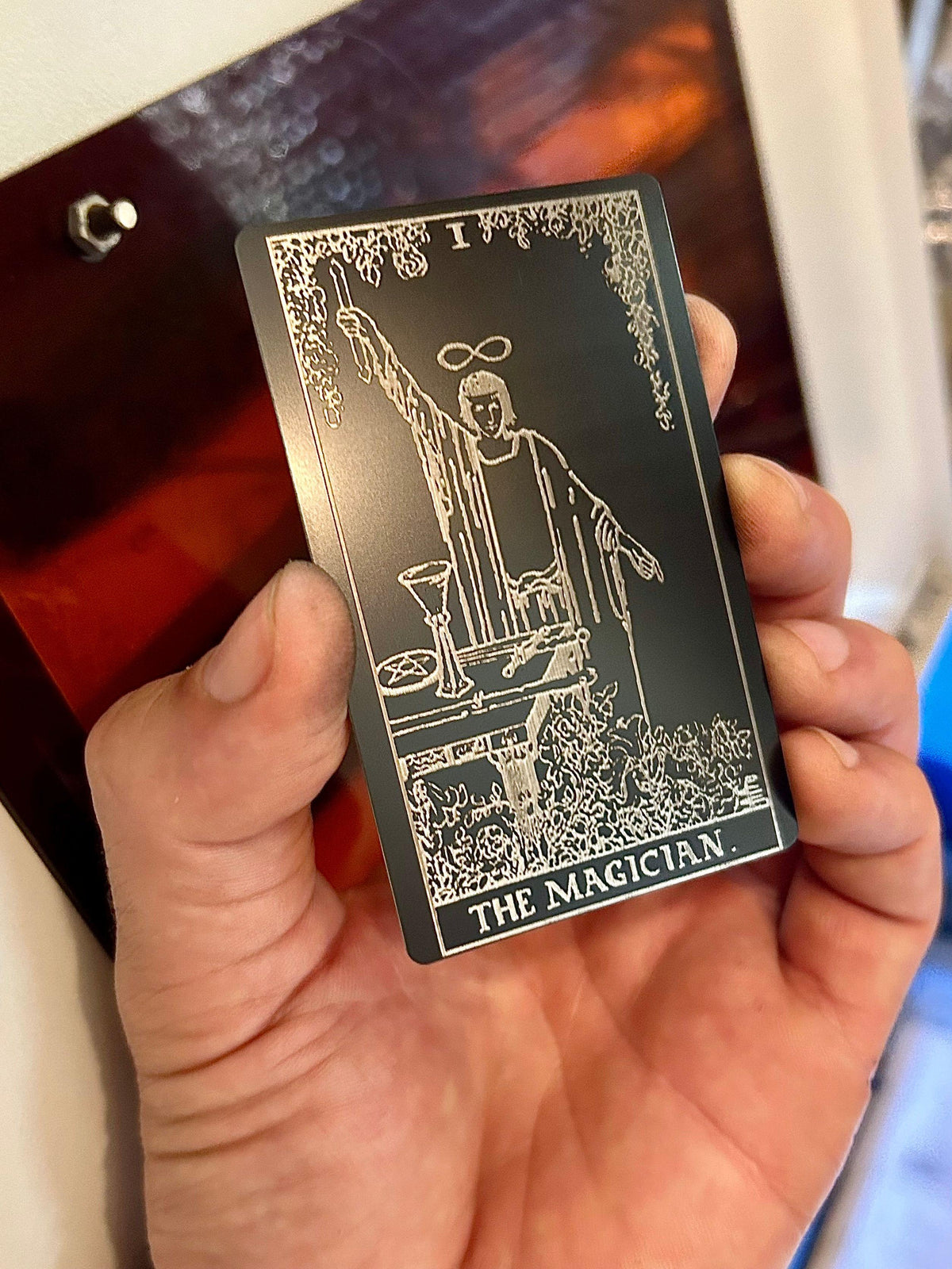 Laser engraved metal tarot card with The Magician artwork in black/silver anodized aluminum