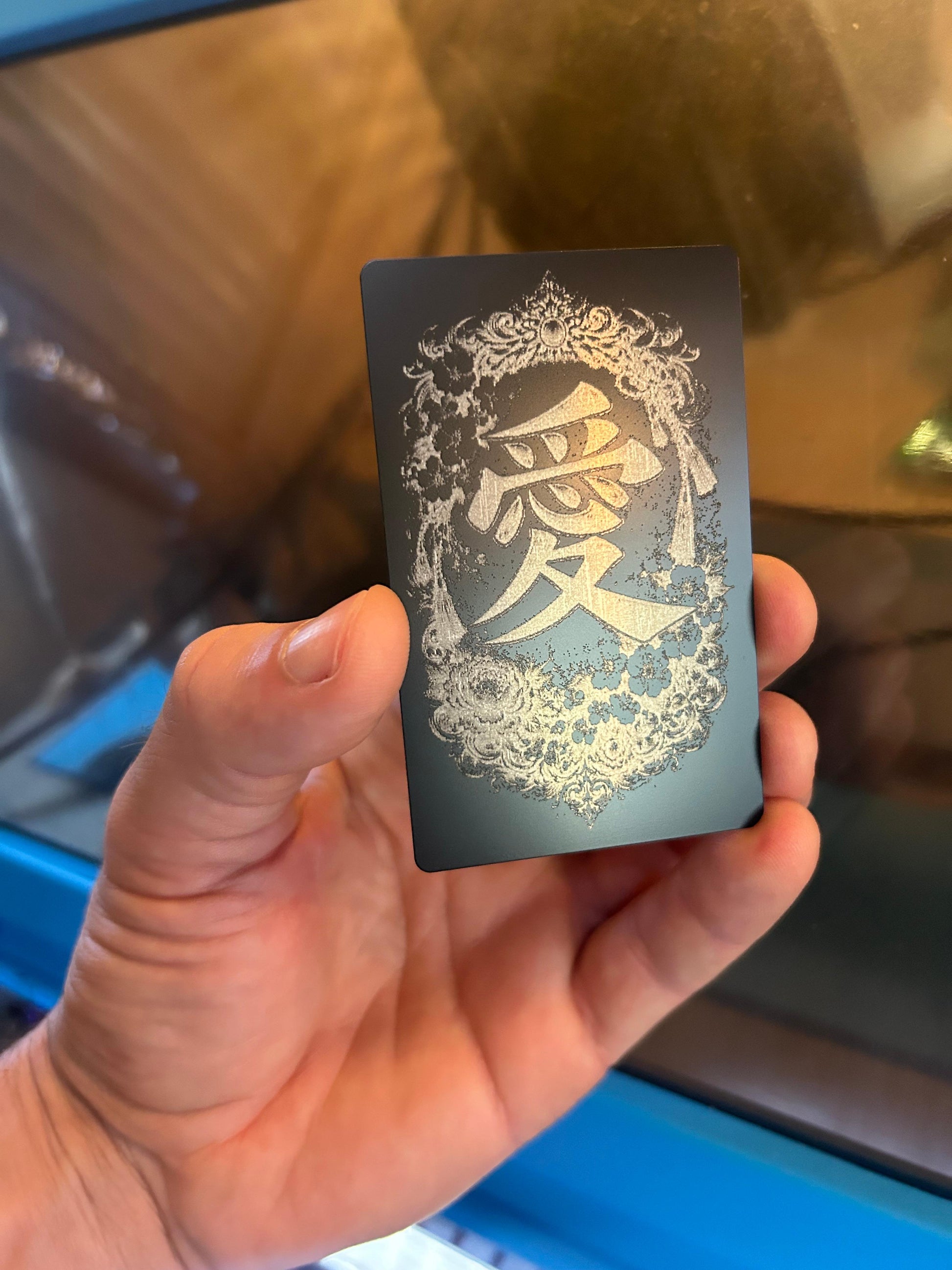 Hand holding a black card with decorative romantic Japanese symbol "Love"