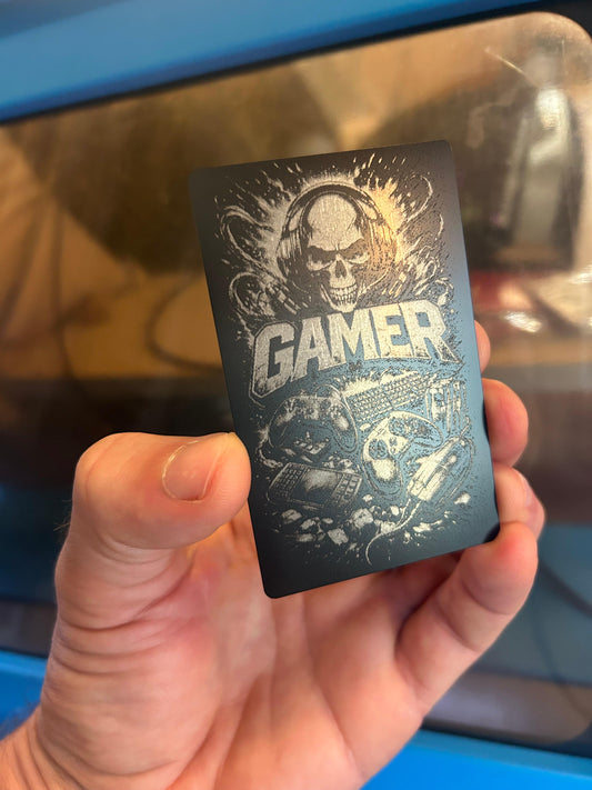 Hand holding a black card with 'Gamer' engraved design
