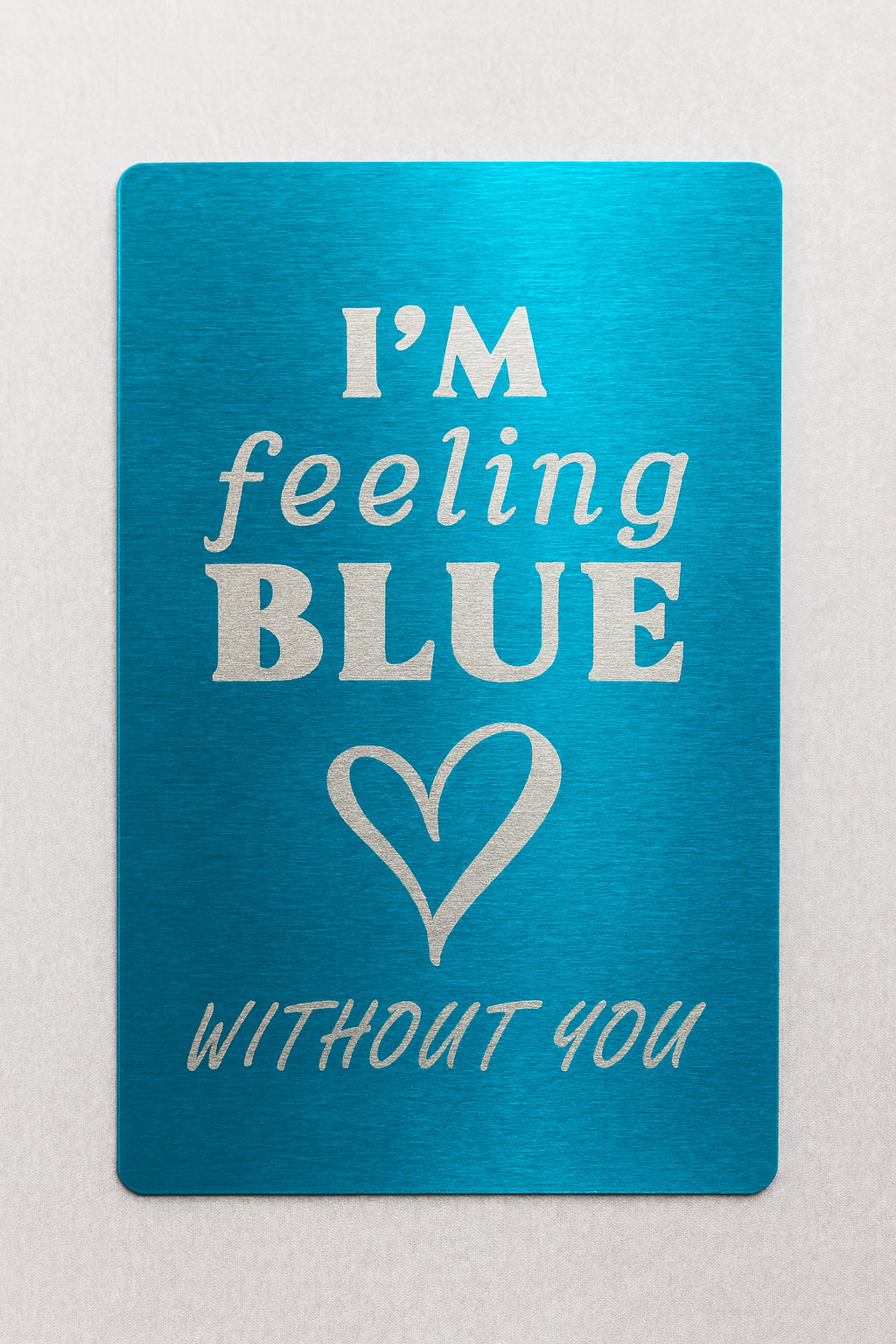 Blue card with silver text and heart symbol on a light gray background