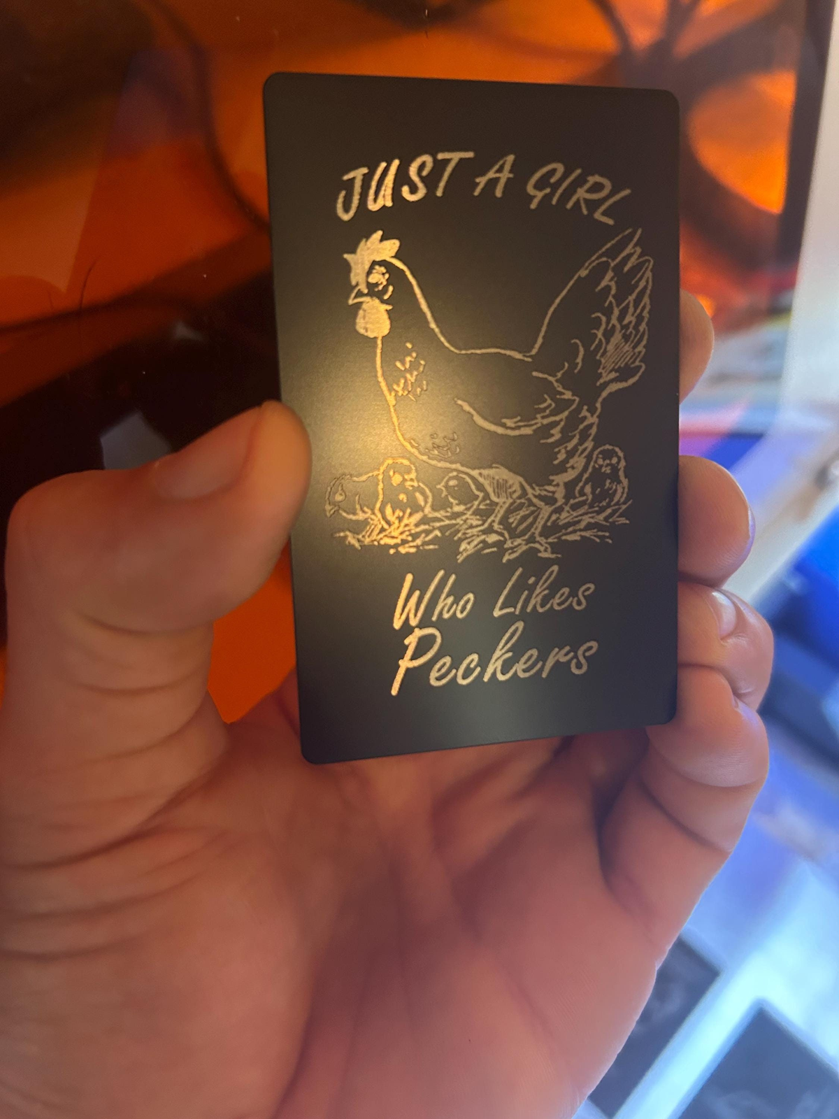 Novelty Friendsgiving metal card engraved with “Just A Girl Who Likes Peckers” and chicken illustration