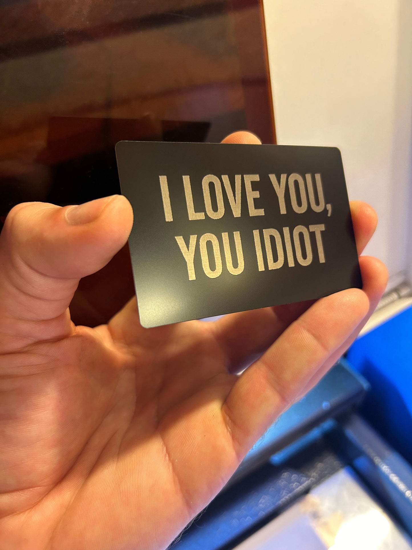 Metal keepsake card with laser engraved typography that reads I Love You, You Idiot