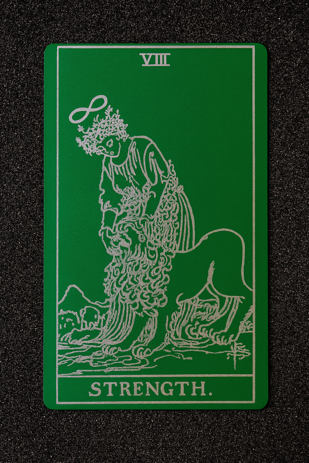 Metal green/silver Tarot card with a green background featuring a lion and the word 'Strength'.