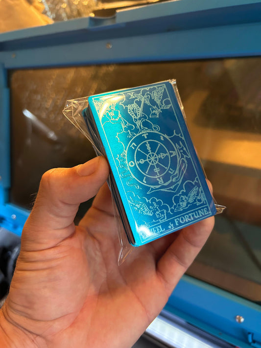 A blue/silver deck of metal tarot cards with Wheel of Fortune on top