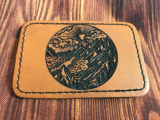 Leather patch with mountain design on a textured fabric background