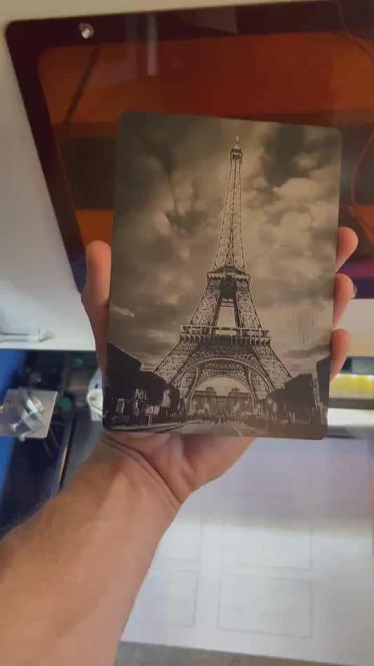 Close-up video of black anodized metal 5x7 plaque rotating to show laser engraved Eiffel tower artwork