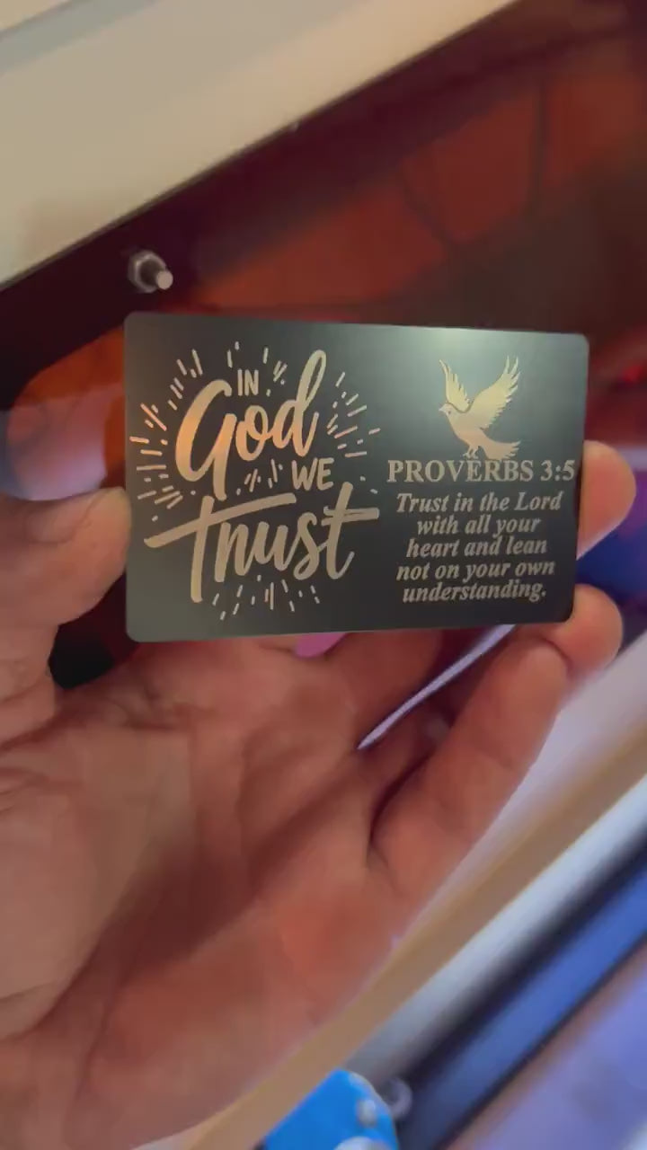 Hand holding In God We Trust laser engraved keepsake gift card with bible verse and dove typographic design