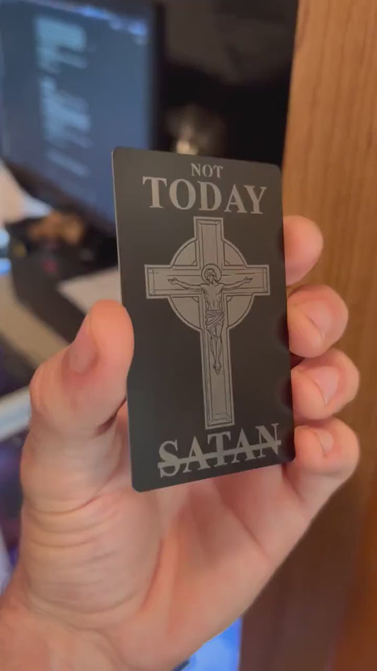 Engraved metal business card turning under light to highlight crucifix design and typography