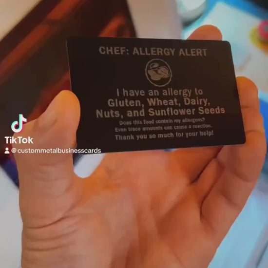 Close up video of hand holding a laser engraved metal gift card with Chef: Allergy Alert, I have an allergy to Gluten, Wheat, Dairy, Nuts, and Sunflower Seeds. Does this food contain my allergens? Even trace amounts can cause a reaction. Thank you so much for your help! 