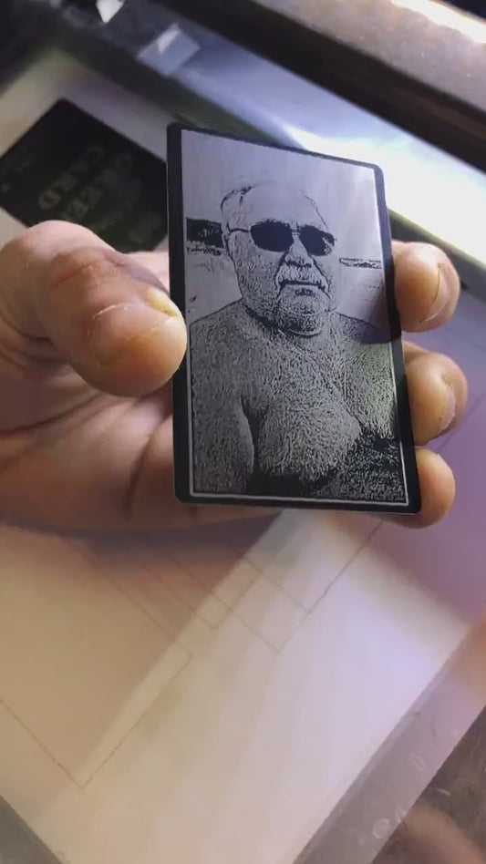 Close up video of hand holding a laser engraved metal photo portrait keepsake card with a picture of someone's father