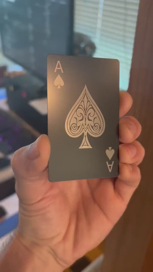 Close up video of hand holding a laser engraved metal gift card with Ace of Spades poker card design in matte black/silver