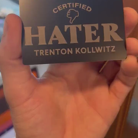 Close-up video of laser engraved metal Certified Hater ID card with personalized name, rotating to show shine and detail