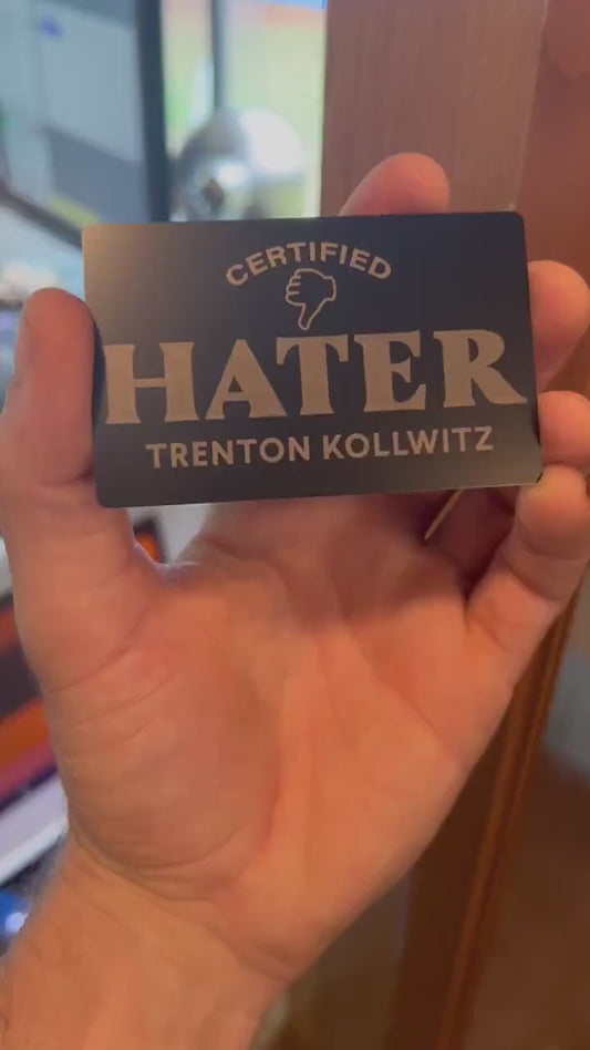 Close-up video of laser engraved metal Certified Hater ID card with personalized name, rotating to show shine and detail