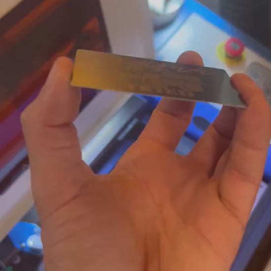 Close up video of hand holding a laser engraved metal gift card with Mama Tried typography & a lifted country themed pickup truck