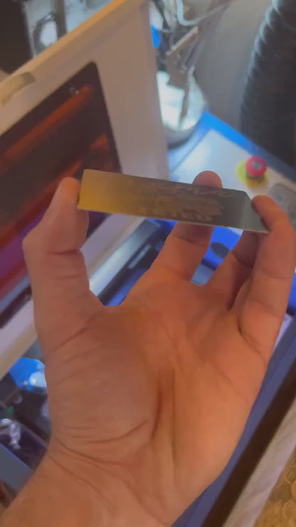 Close up video of hand holding a laser engraved metal gift card with Mama Tried typography & a lifted country themed pickup truck