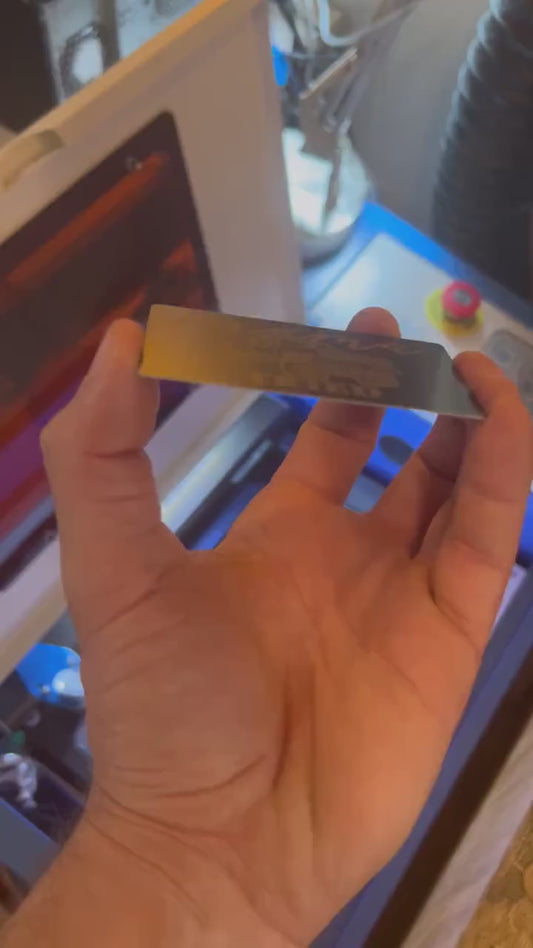 Close up video of hand holding a laser engraved metal gift card with Mama Tried typography & a lifted country themed pickup truck