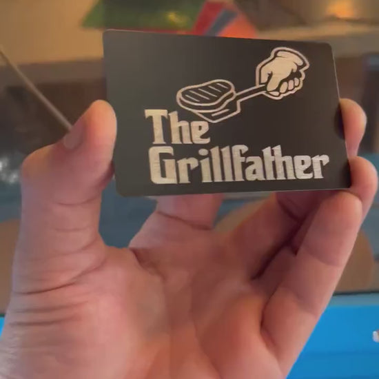 Video of engraved metal wallet Grill Father card turning under light to show reflective finish