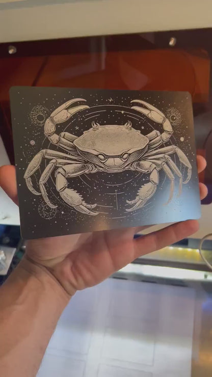 Hand holding laser engraved metal 5x7 plaque with cancer crab spiritual astrology zodiac artwork