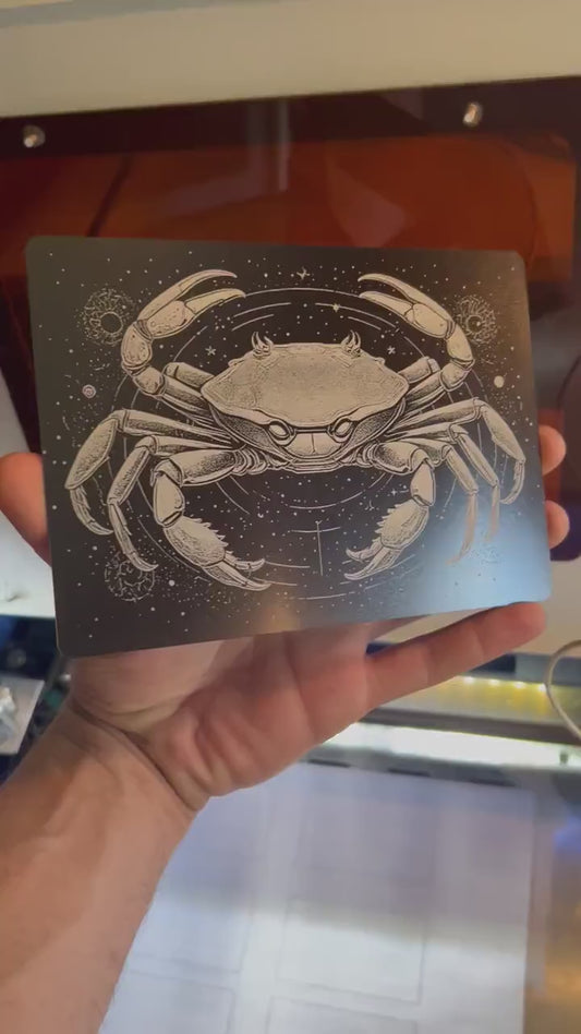 Hand holding laser engraved metal 5x7 plaque with cancer crab spiritual astrology zodiac artwork