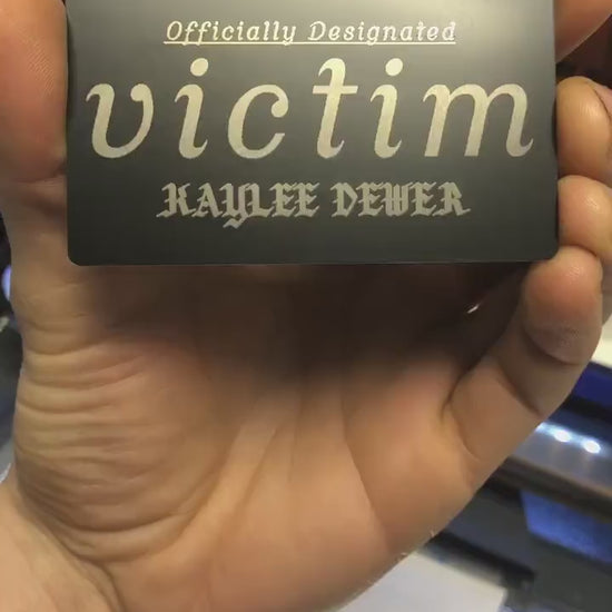 Hands rotating personalized metal bad bitch id card to display engraved text