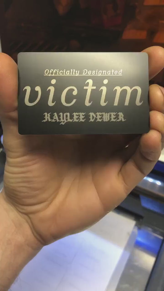 Hands rotating personalized metal bad bitch id card to display engraved text