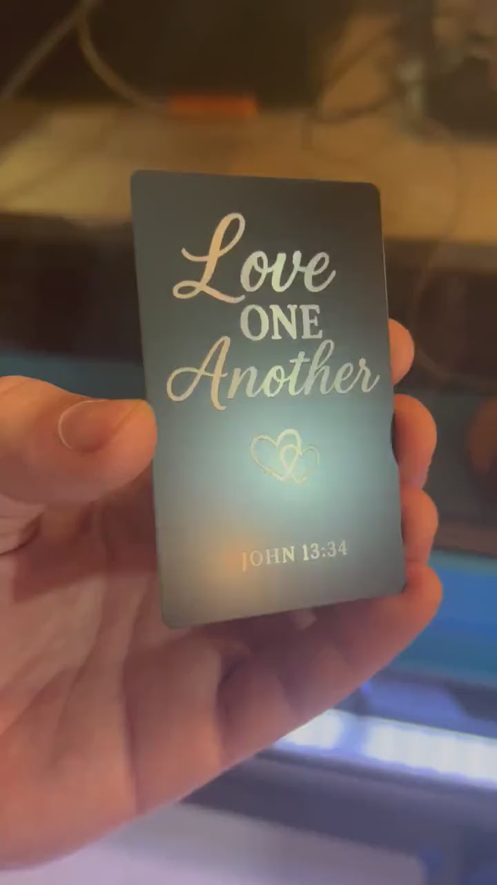 Close-up of engraved anodized aluminum scripture plaque featuring “Love One Another” message with Bible verse
