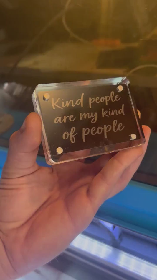 Hand holding a laser engraved black/silver Kind People are my kind of people metal keepsake wallet insert card, shown in optional acrylic display case