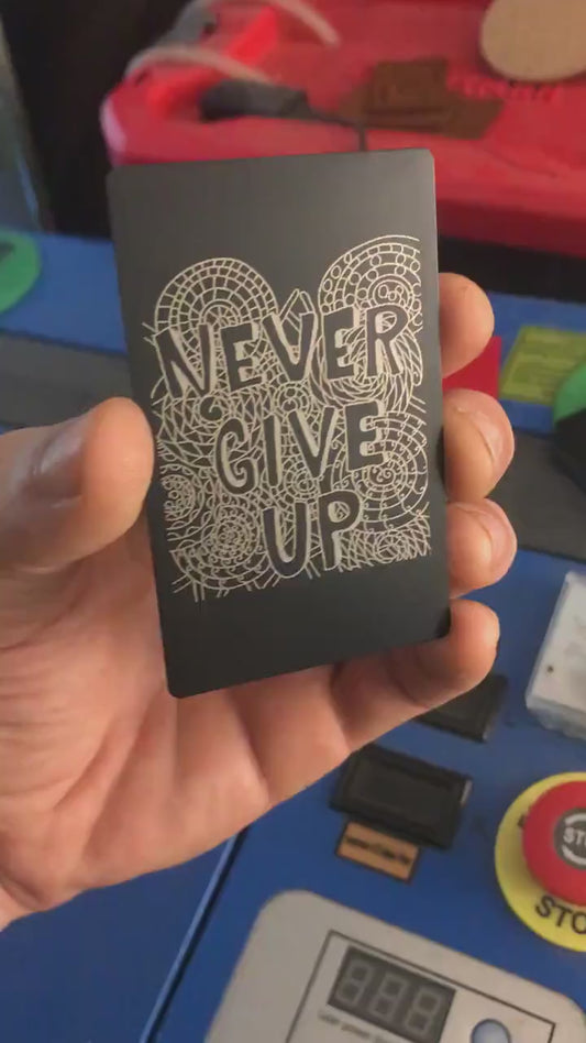Laser engraved metal motivational reminder keepsake that reads Never Give Up with psychedelic pattern print