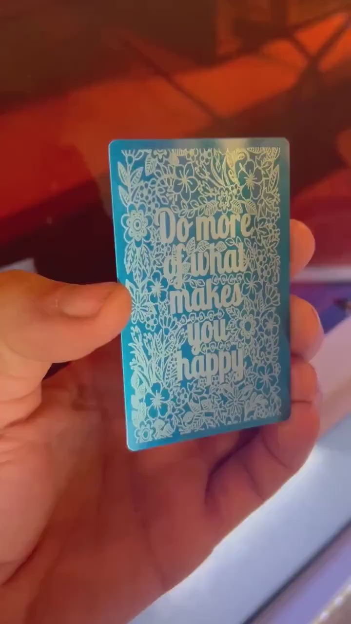 Laser engraved blue/silver novelty keepsake gift that reads Do More of What Makes You Happy, in blue/silver anodized aluminum