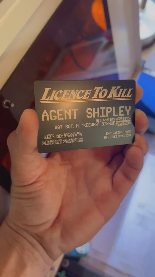 Hand holding a metal customized keepsake cosplay wallet card that reads License To Kill with custom name and text