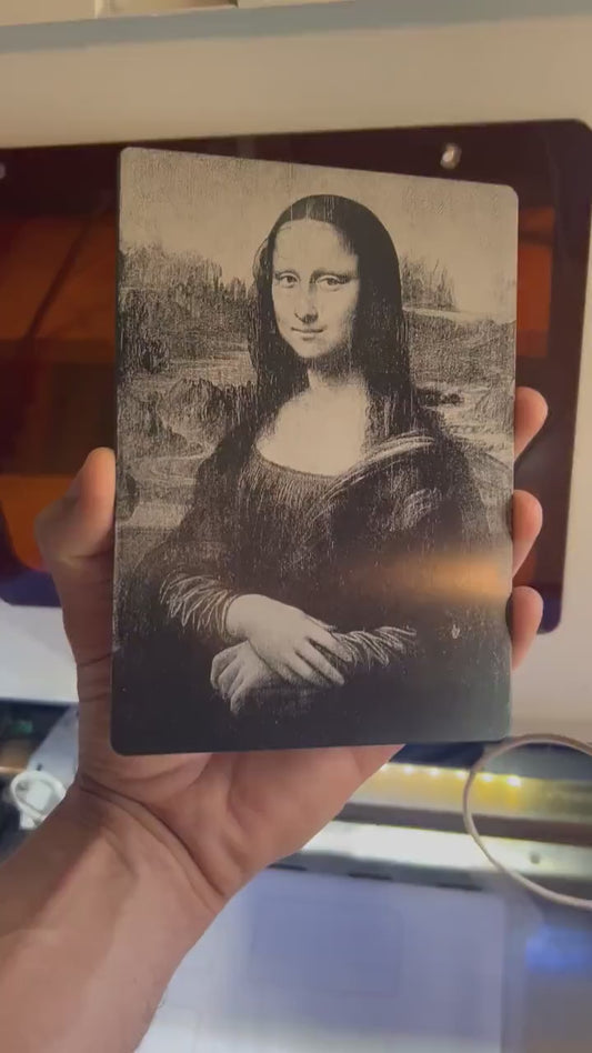 Hand holding a laser engraved 5x7 metal Mona Lisa plaque in anodized aluminum